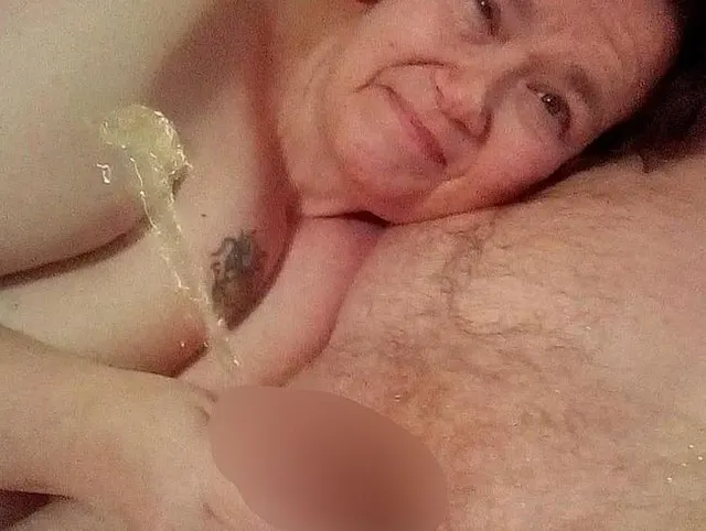 John pisst, als Jen ihm einen Handjob auf dem Bett gibt