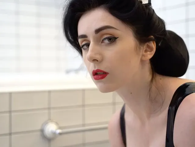 Das Mädchen aus Latex wäscht den Boden