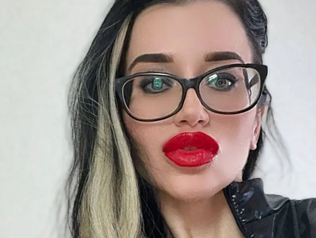 Lederoutfit, Spielzeug, roter Lippenstift auf den Lippen und rote lange Nägel