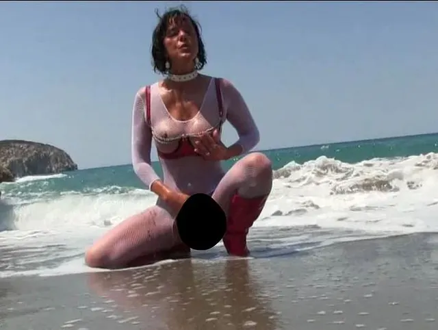 Nanalou red latex bra and bud plug in her ass sucking at the beach