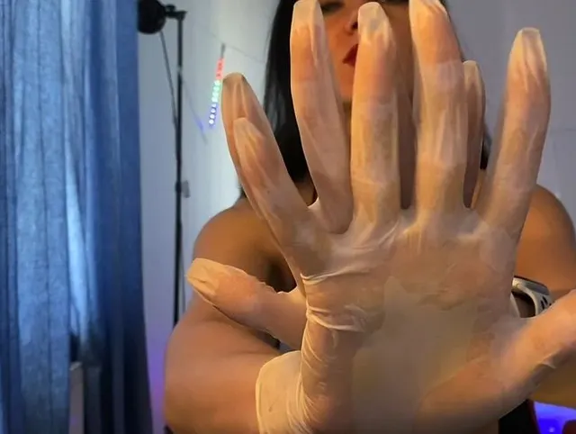 Herrin mit nackten Brüsten in weißen medizinischen Handschuhen