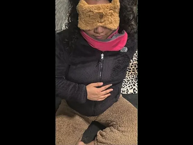 Eingehüllt in ein rosa Fleece mit einem schwarzen Fleece darüber und einer flauschigen braunen Teddy-Pyjamahose