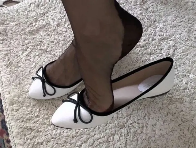 Schuhspiel weiße Ballerinas und schwarze Nahtnylonstrümpfe