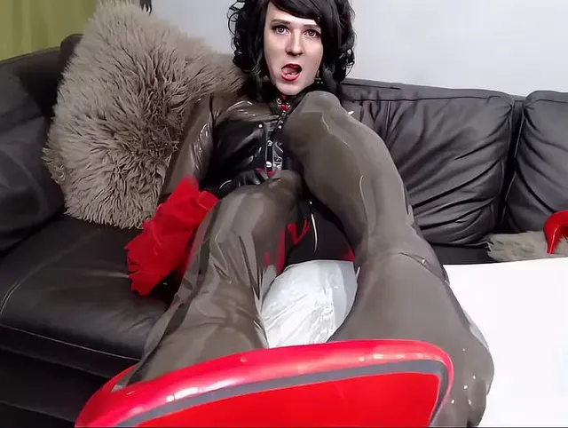 Halbtransparenter Latex-Catsuit auf dem Sofa