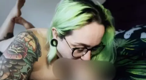 Mit Lippenstift an einem Dildo lutschen