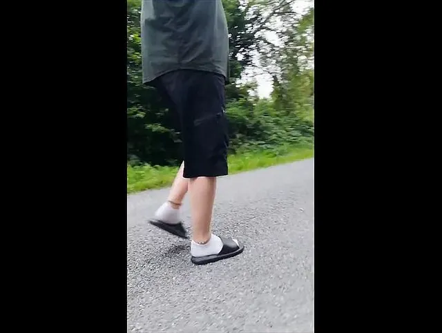 In Latschen und weißen Socken in der Natur
