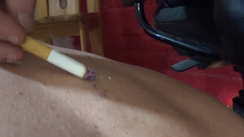 Mistress plays with cigarette on slaves body